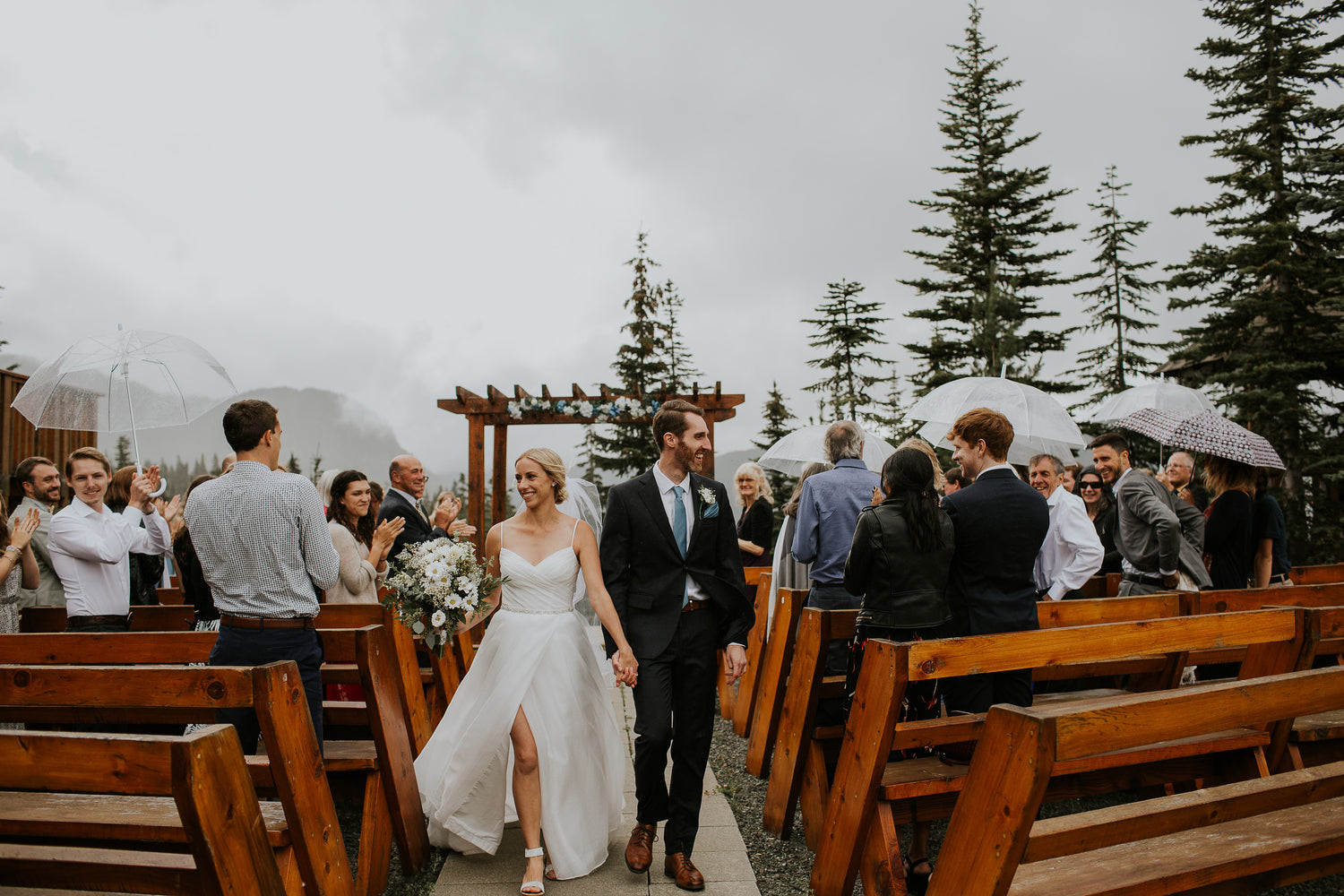 bride and groom walking down the aisle in the rain