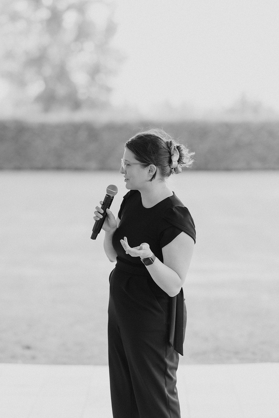 Nicole in a black outfit speaking into a microphone