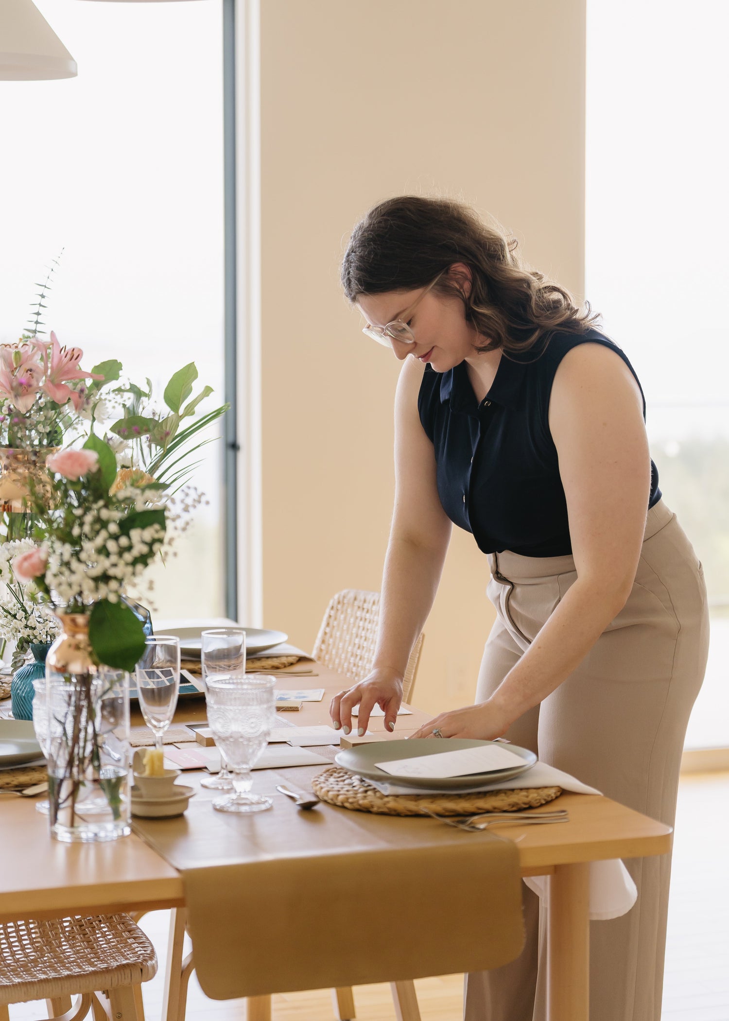 Nicole Grogan owner and lead planner Intended Weddings and Events looking at elements for a table styling with plates and colours. Vancouver Island Wedding Planner, Victoria Wedding Planner, Event Planner - Rebecca Crooks Photography