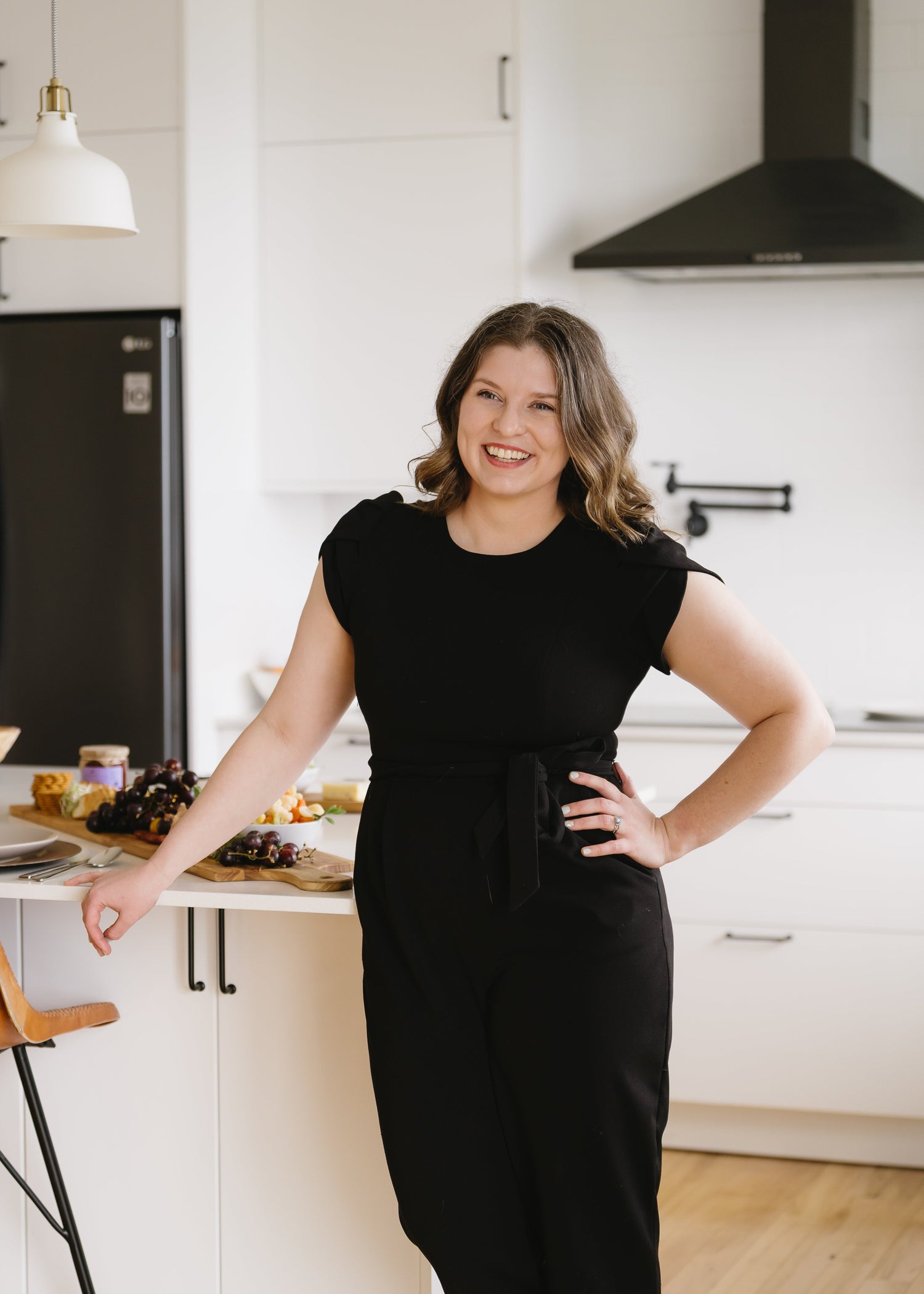 Nicole Grogan owner and lead planner at Intended Weddings and Events, posing in a black jumpsuit in a kitchen. Vancouver Island Wedding Planner, Victoria BC Wedding Planner, Victoria Event Planner - - Rebecca Crooks Photography