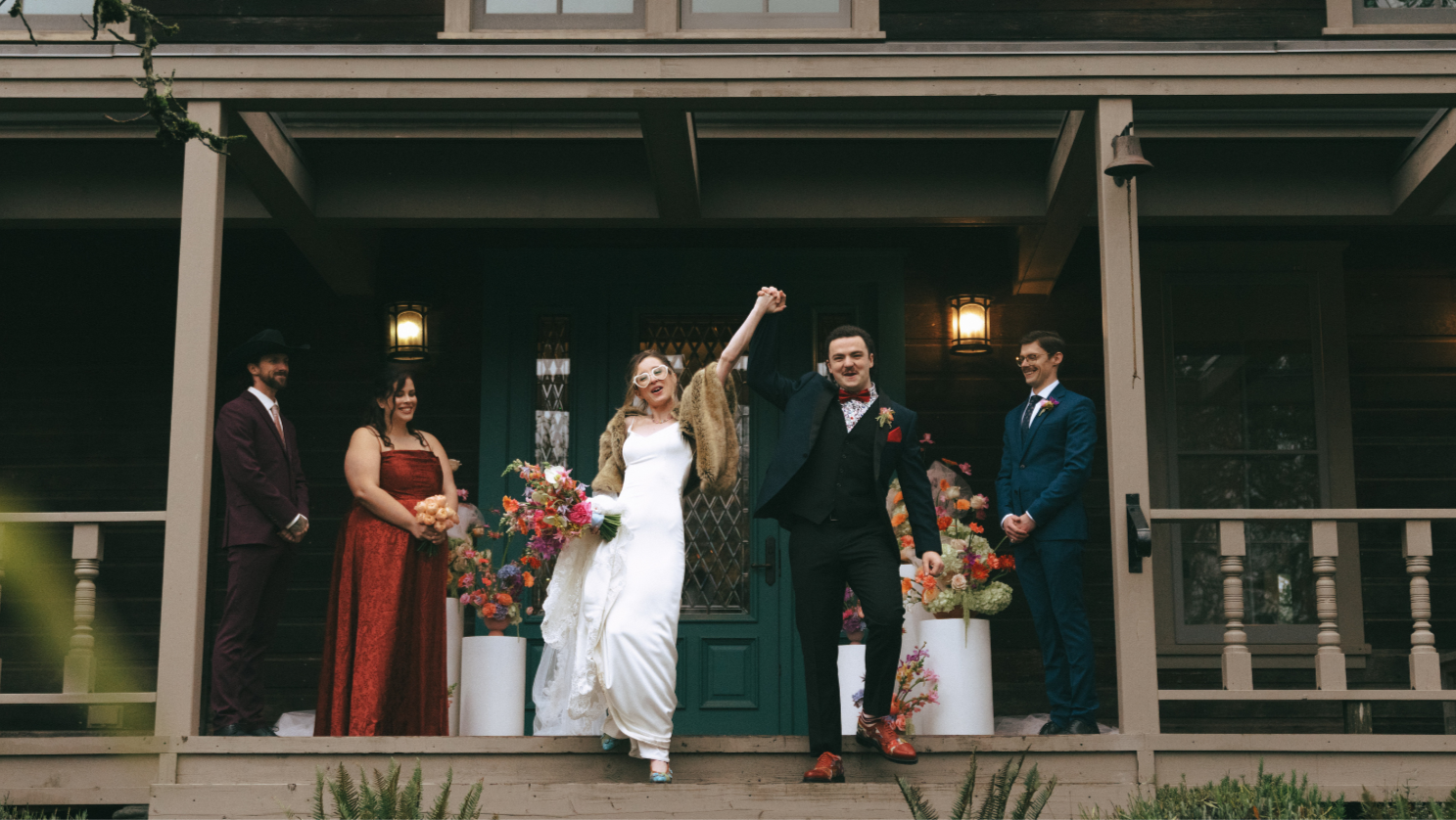 Newly married bride and groom celebrate after their ceremony on the front porch of a heritage house at Keating Farm, Duncan, Vancouver Island wedding. Taylor Dawning Photography