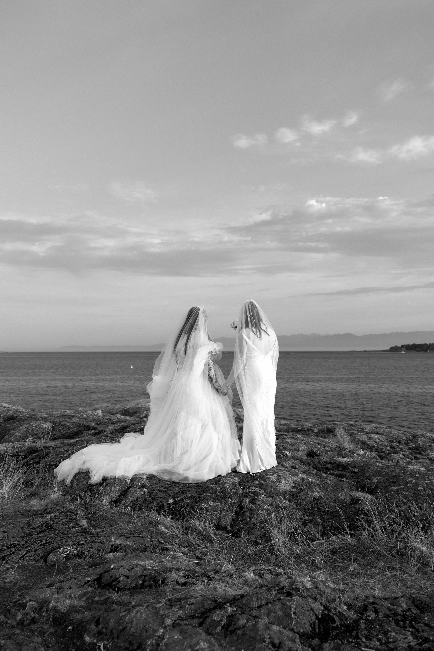Two brides in white gowns overlooking the ocean. Victoria BC Wedding, Vancouver Island Wedding, Fort Common, Kiana Bryn Photography