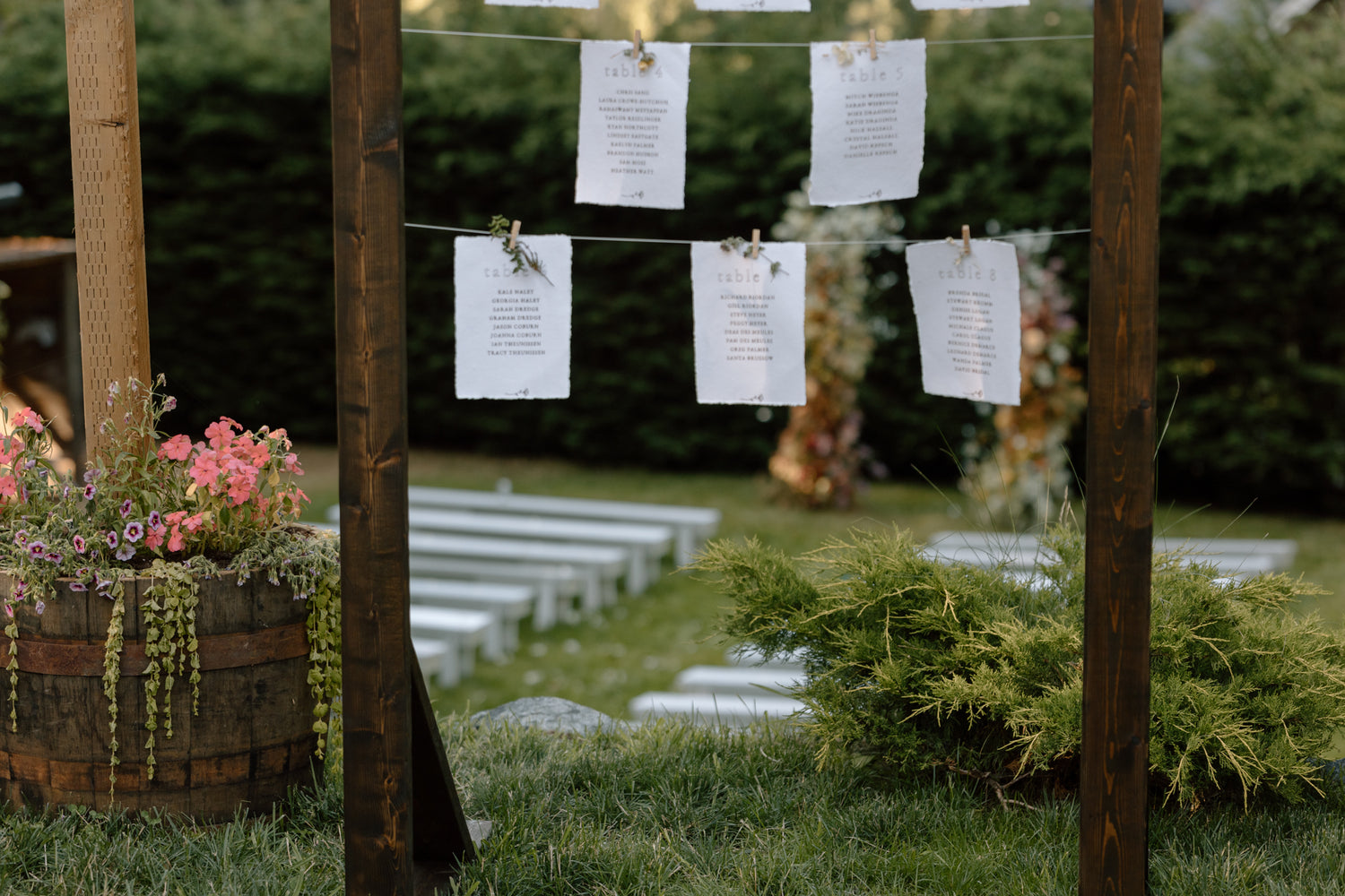 a seating chart in the foreground with the ceremony site and floral arch in the background