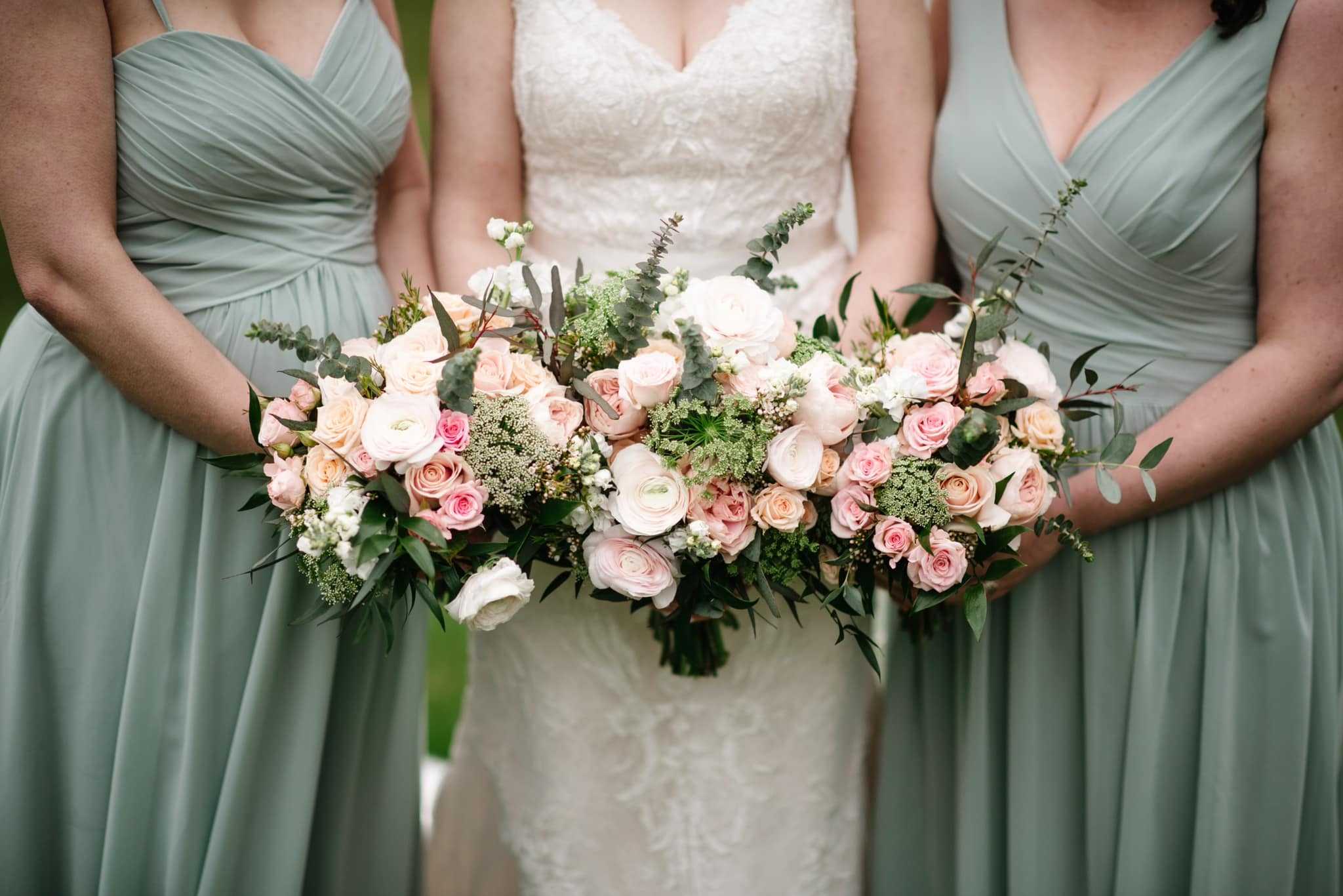 background image of a bride and two bridesmaids holding their pink and white bouquets