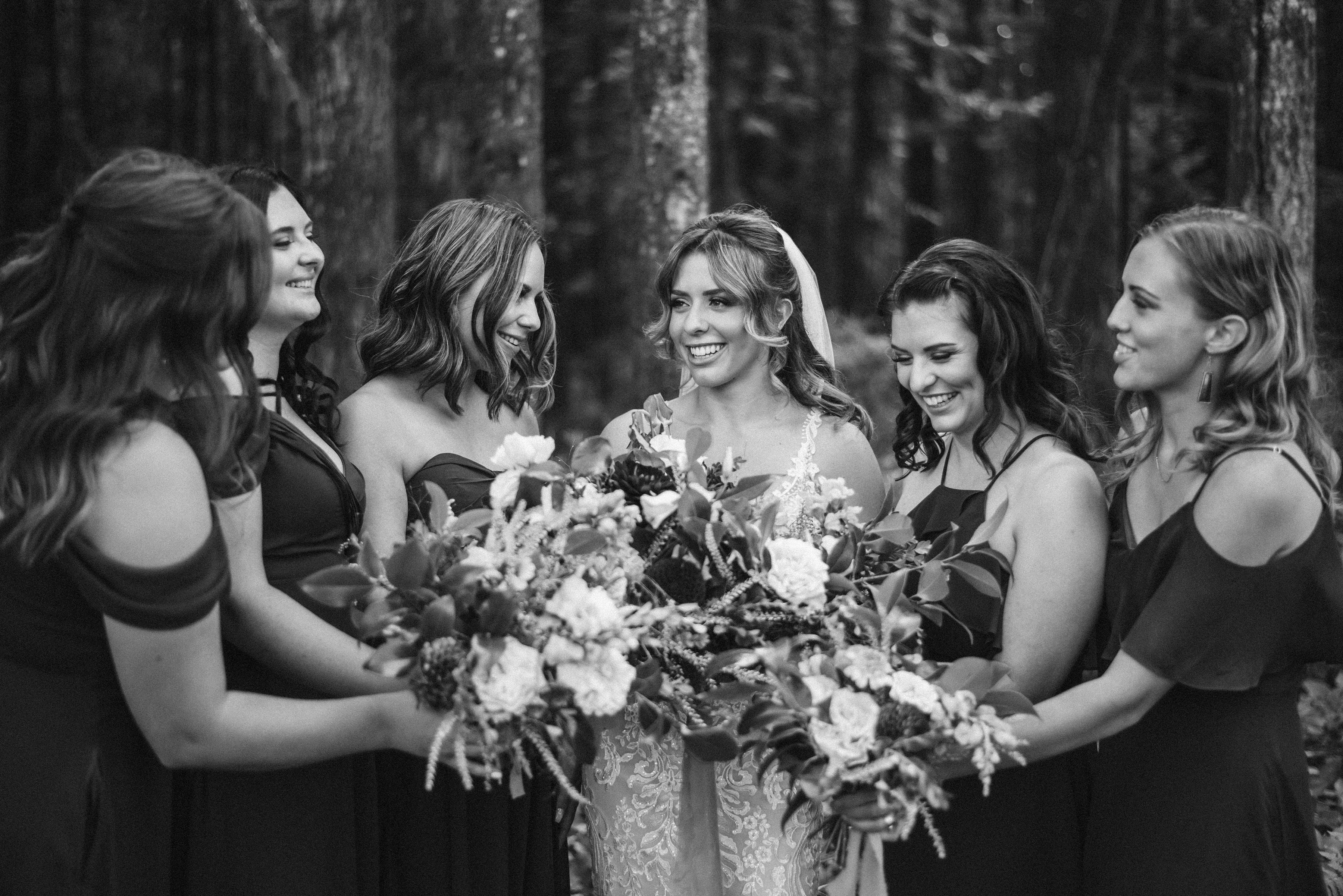 bride with bouquet surrounded by bridesmaids holding bouquets