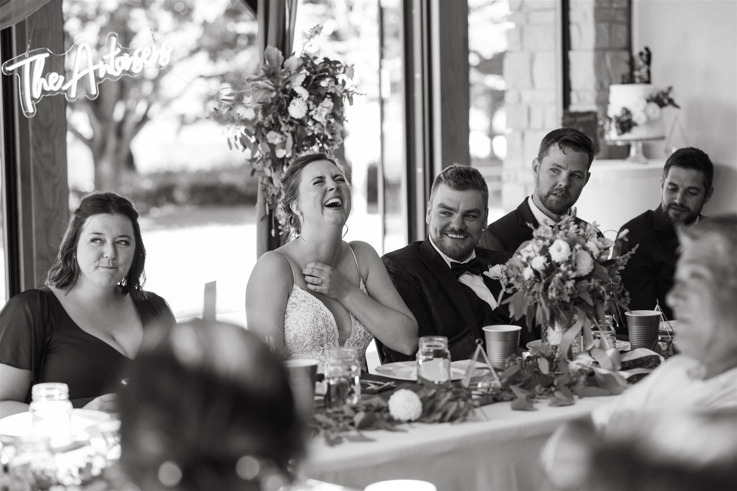 a wedding party laughing during speeches